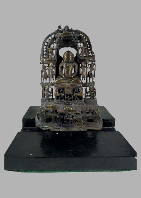 BRONZE JINA SEATED IN SHRINE WITH PRABHAVALI