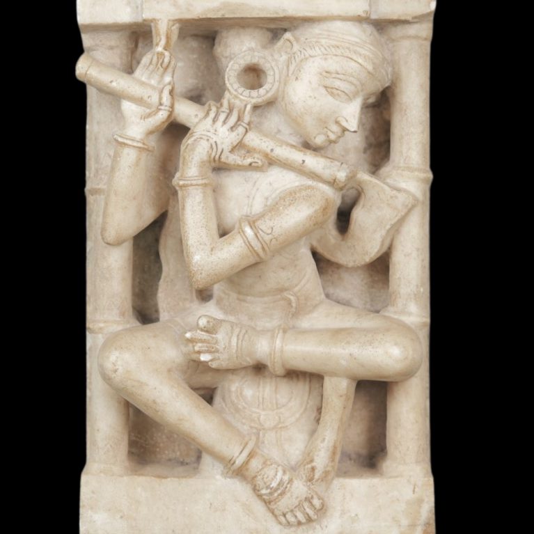 MARBLE SCULPTURE OF FLUTE PLAYER IN ARCHITECTURAL NICHE